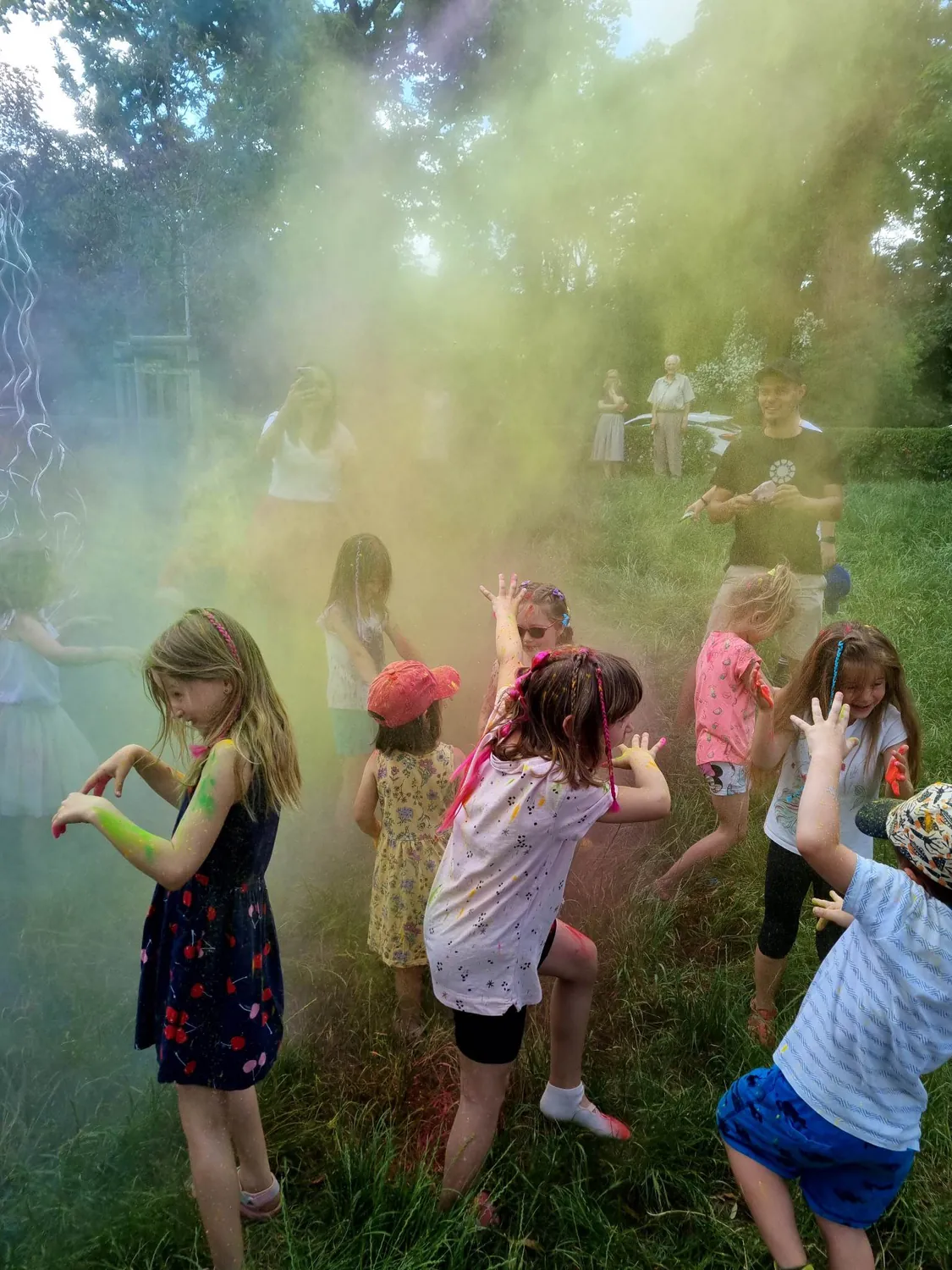 Dzieci bawią się kolorowymi proszkami Holi podczas animacji plenerowej
