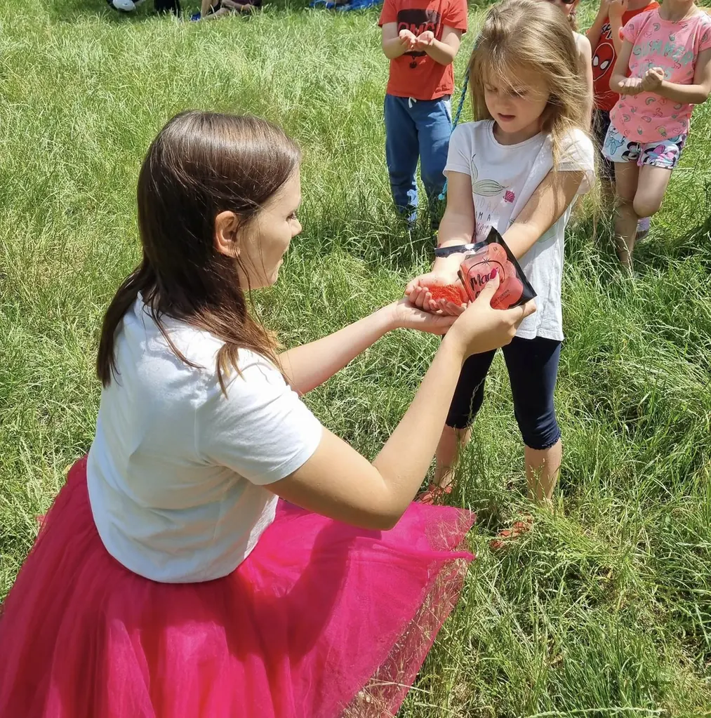 Animatorka wykonuje kolorową ozdobę na dłoni dziecka